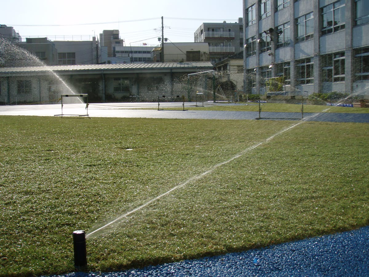 校庭の施工例 校庭ハイブリッド芝生化した小学校へ散水機導入